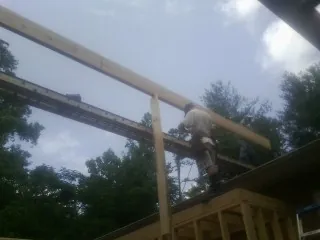 Carpenter setting a ridge beam over a new addition frame — Ice Dam Removal by Roofing Brothers in Northridge