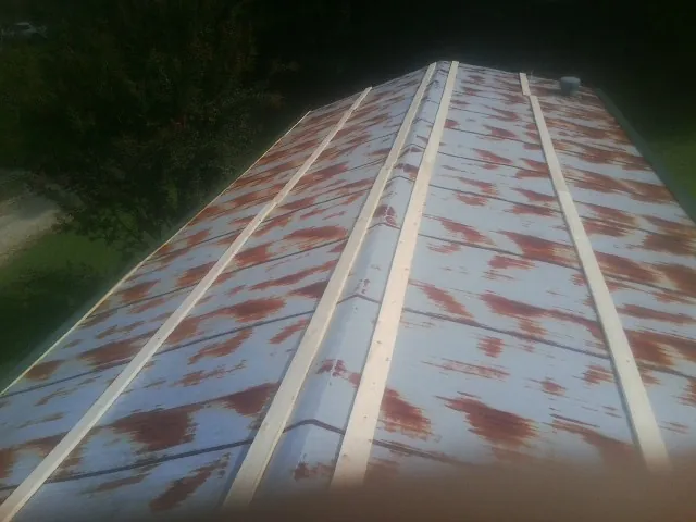 Rusted metal roof panels with new wood purlins before replacement — Storm Damage Roof Repair in Northridge by Roofing Brothers